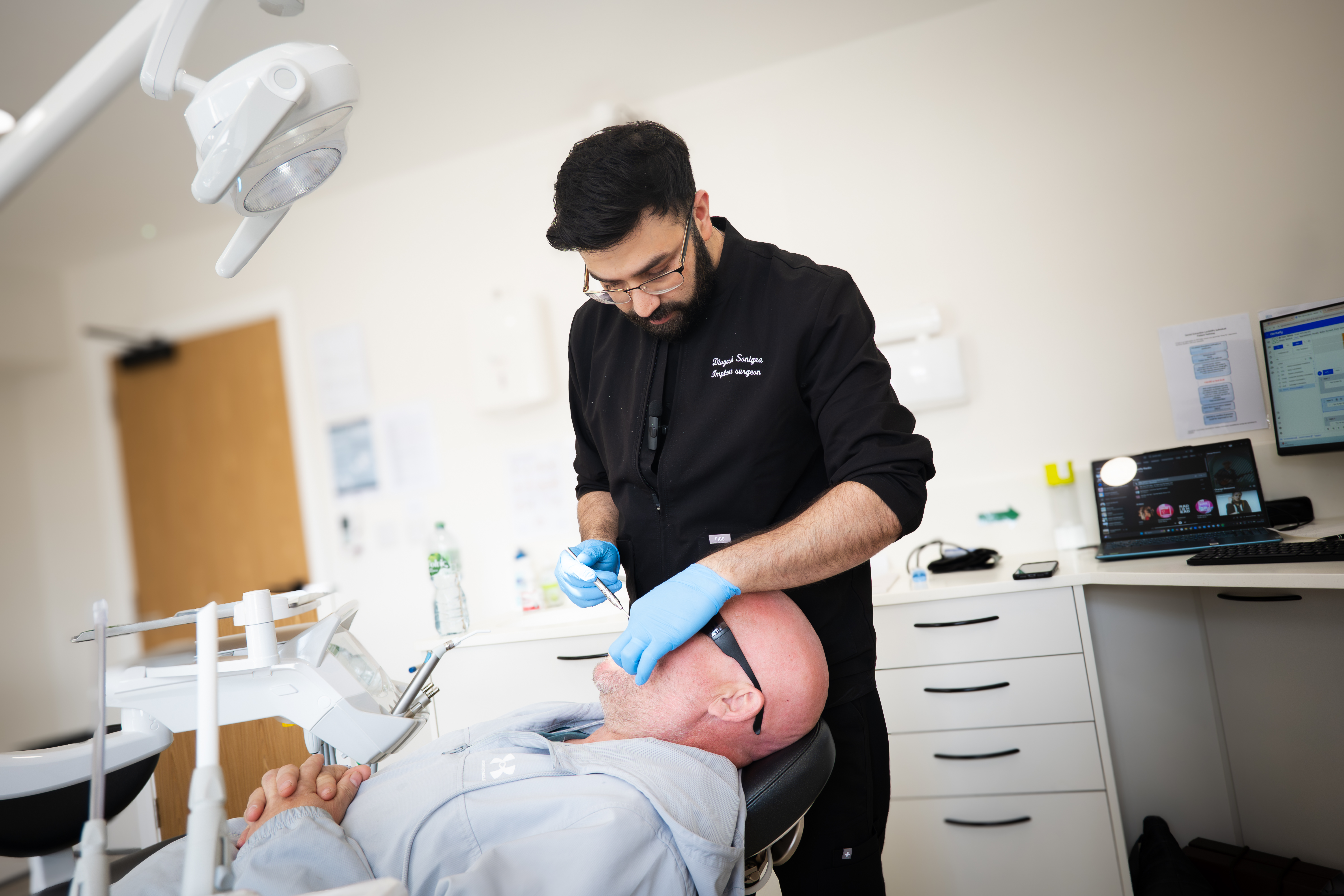 Implant surgeon assessing a patient at Dream Smiles Dental Bolton