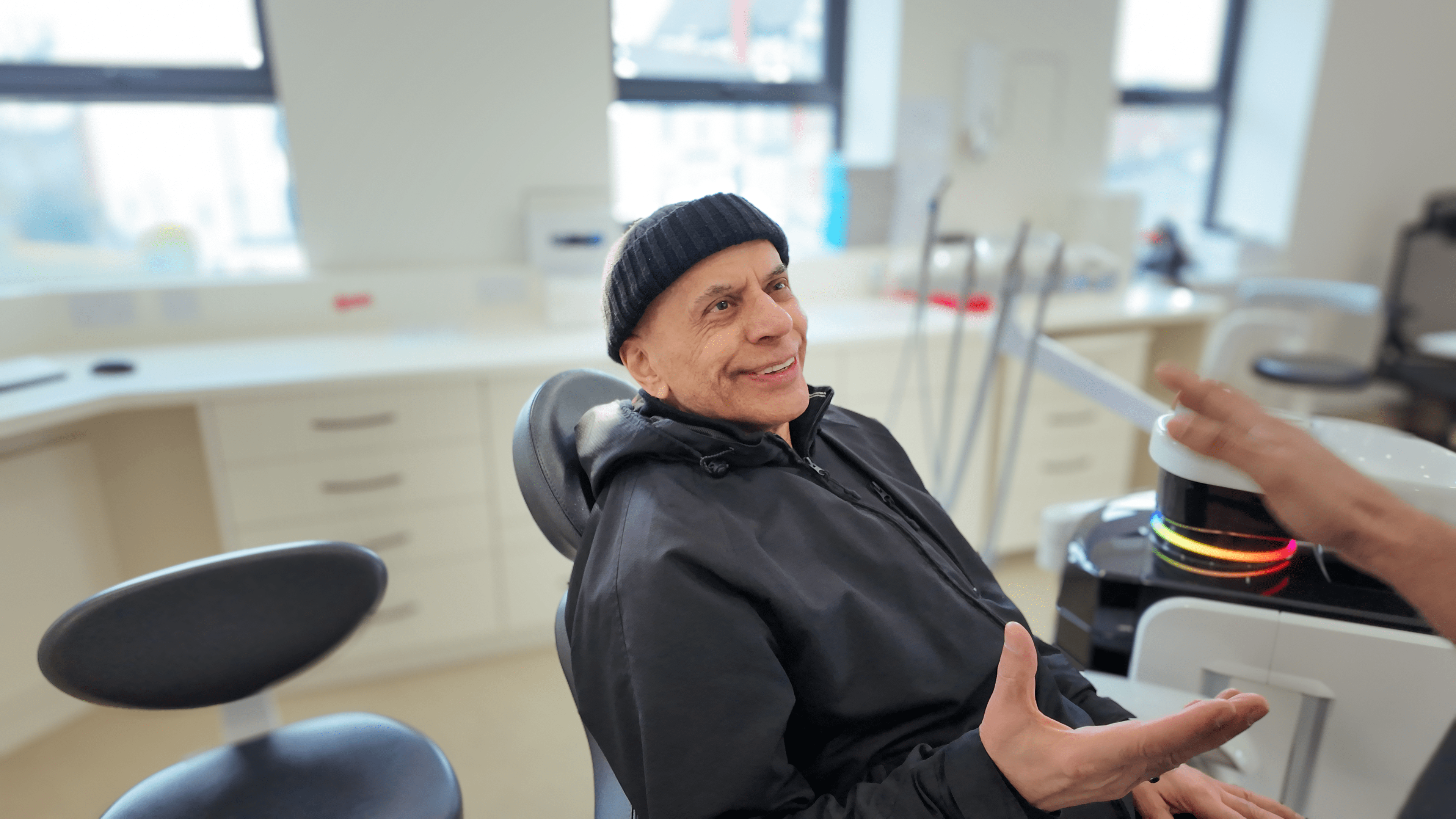 Older male patient smiling in the dental chair after receiving dental bridges at Dream Smiles Dental