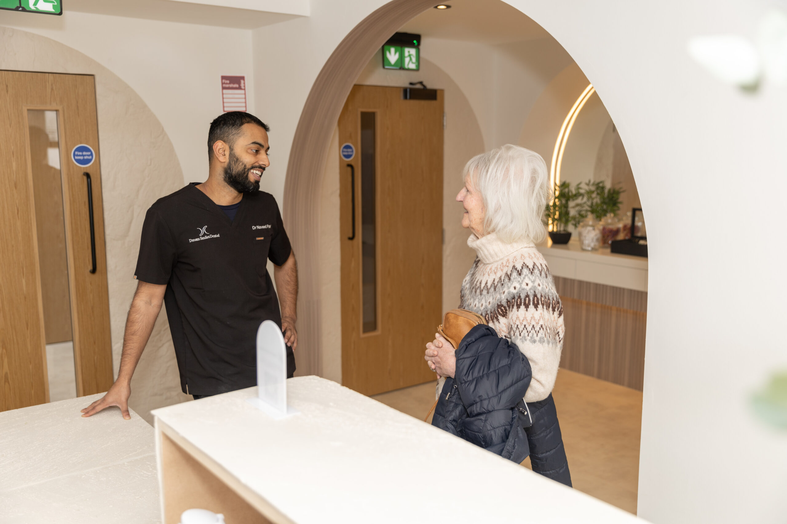 Dream Smiles Dental receptionist welcoming a patient to the clinic for dental crown treatment