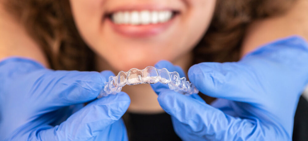 Orthodontist doctor putting invisible transparent braces
