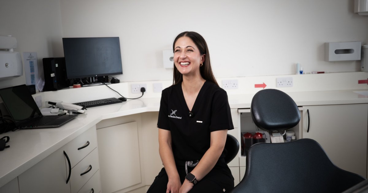 Dr Brekhna smiling in a consultation room at Dream Smiles Dental in Bolton
